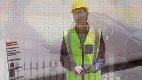 Construction worker wearing hard hat holding tablet at pipeline site, displaying Stock Footage 307463279