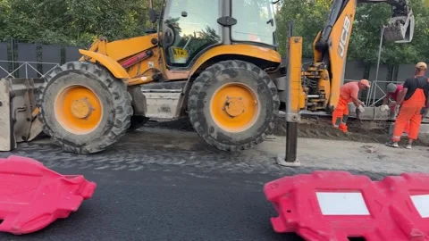 A construction worker wearing a hard hat and reflective vest stands Stock Footage 310140289