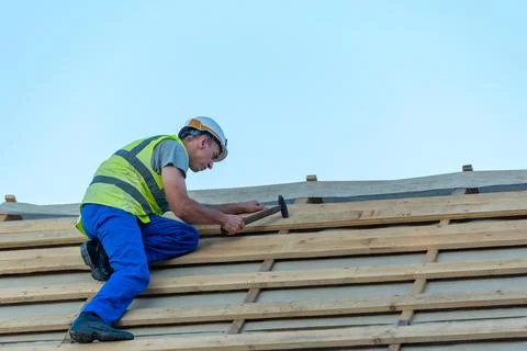 Construction worker wearing a hard hat and safety vest installing horizonta.. Stock-Fotos
