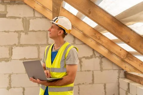 Construction worker wearing a hard hat and high visibility vest uses a port.. Stock Photos