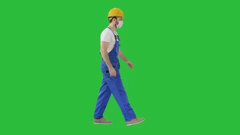 Construction worker wearing a hardhat and mask walking on a Green Screen, Chroma Stock Footage 129340112