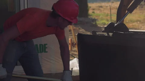 Construction worker wearing hardhat pulling concrete from machine Stock Footage 55145910