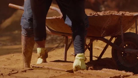 Construction worker wearing protective gloves stacking adobe bricks near Stock Footage 316760348