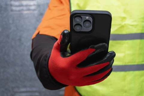 Construction worker wearing protective gloves and reflective safety vest wh.. Stock Photos