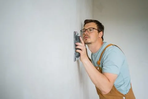 Construction worker wearing safety glasses and protective brown overalls Stock Photos