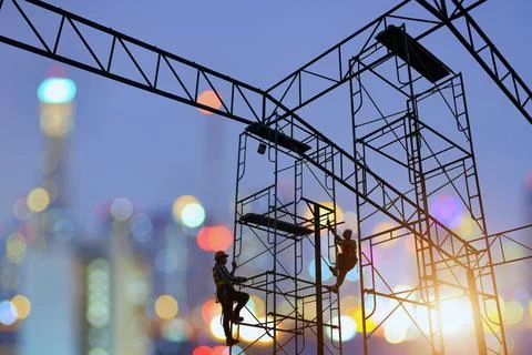 Construction worker wearing safety work at high uniform on scaffolding at con Stock Photos