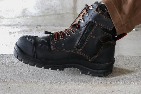 A construction worker wears brown leather boots Stock Photos