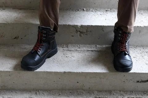 A construction worker wears brown leather boots Stock Photos