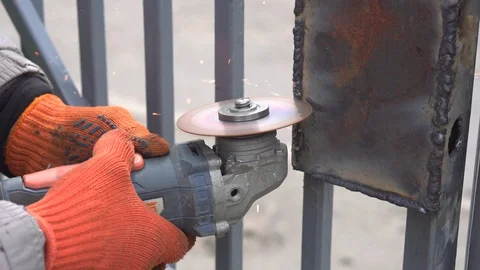 A construction worker welder cuts a metal profile with a grinder Stock Footage 129465840