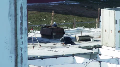 Construction worker welding on concrete slab at outdoor building site with Stock Footage 325698875