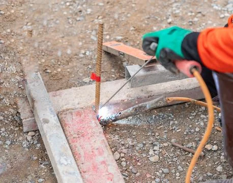 Construction worker welding metal formwork. Stock Photos