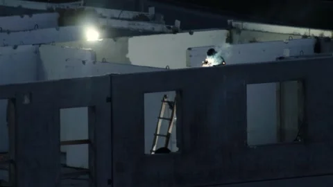 Construction worker welding metal structure during night on building site Stock Footage 325698988