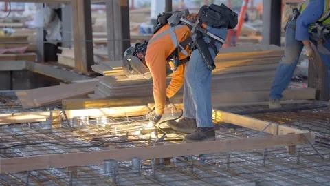 A construction worker welding steel on a construction site creating sparks Stock Footage 270879232