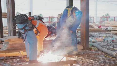 Construction worker welding steel on a construction site creating sparks Stock Footage 270879294