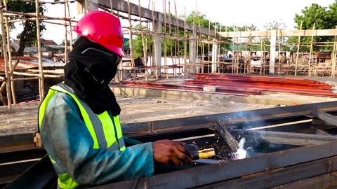 Construction worker welding a steel frame at an active building site with 動画素材 340382376