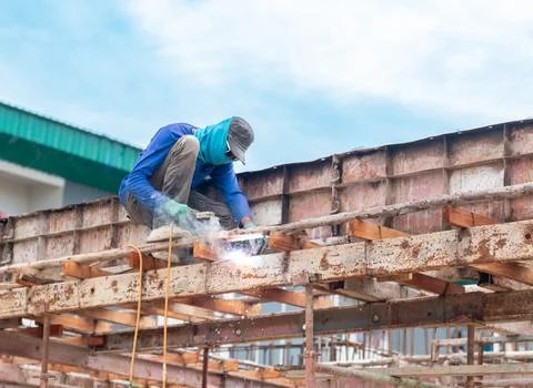 Construction worker welding steel structure on a high-altitude scaffolding .. 스톡 사진