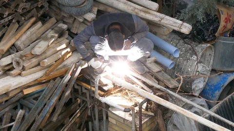 Construction worker welding without a protection mask in a dangerous unsafe way Stock Footage 96131397