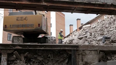 Construction worker working on a building site with digger Video stock 134911160