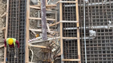 Construction Worker Working on Rebar Cages for Column Foundations Stock Footage 333008474