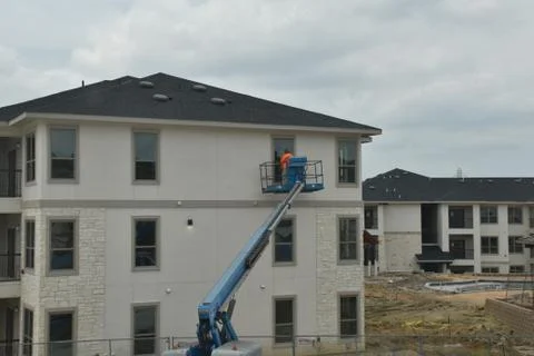 A construction worker working using boom lift vehicle on day in an apartment  Stock Photos
