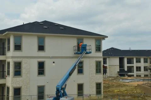 A construction worker working using boom lift vehicle on day in an apartment  Stock Photos