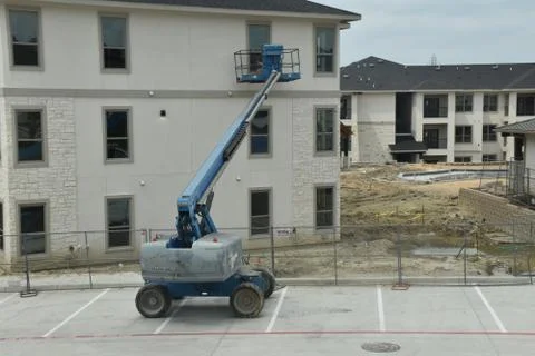 A construction worker working using boom lift vehicle on day in an apartment  Stock Photos