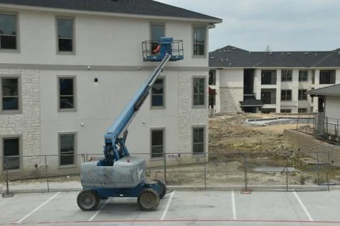 A construction worker working using boom lift vehicle on day in an apartment  Stock Photos
