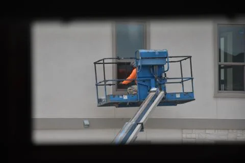 A construction worker working using boom lift vehicle on day in an apartment  Stock Photos