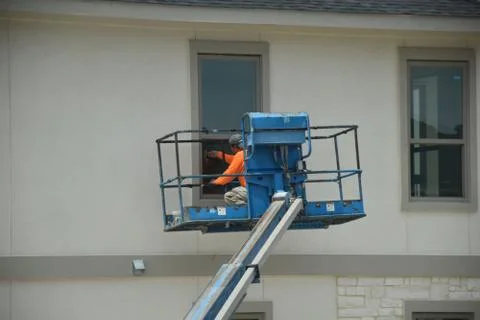 A construction worker working using boom lift vehicle on day in an apartment  Stock Photos