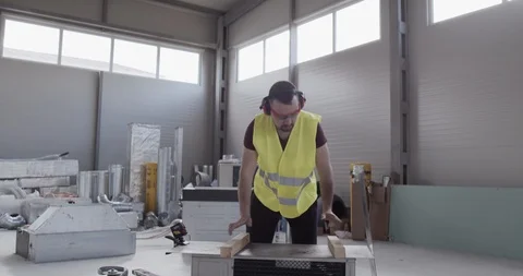 A construction worker works in a warehouse and cuts a sheet metal. Stock Footage 127202574