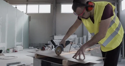 A construction worker works in a warehouse and cuts a sheet metal. Stock Footage 127203544