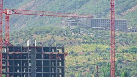 Construction workers and crane building in mountain landscape 스톡 동영상 344799235