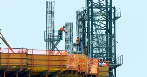 Construction workers and crane install metal frame at development site 4K RAW Stock Footage 66953126