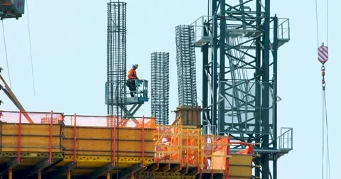 Construction workers and crane install metal frame at development site, 4K, RAW Stock Footage 66953213