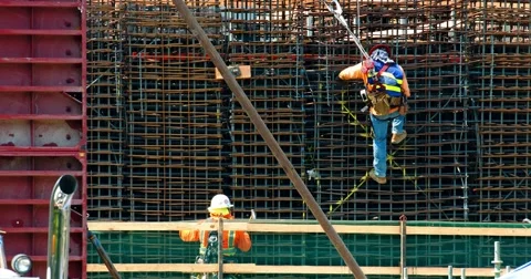 Construction workers and crane install metal frame at development site 4K  RAW Stock Footage 67012133