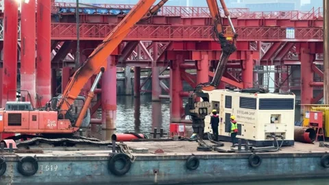 Construction workers and heavy machinery operate on Qiantang River bridge Stock Footage 335355970