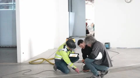 Construction workers and supervisor reviewing floor layout and discussing work Stock Footage 332528218