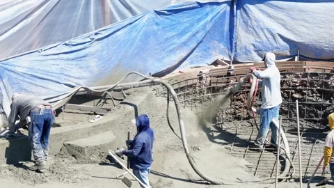 Construction workers apply gunite concrete to backyard swimming pool under Stock Footage 333398286