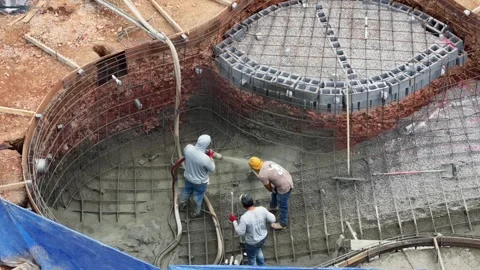 Construction workers applying gunite concrete inside residential swimming pool Stock Footage 333611214