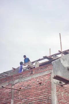 Construction workers are above doing the installation of wooden frames for ro Stock Photos