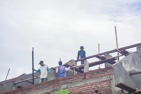 Construction workers are above doing the installation of wooden frames for ro Stock Photos