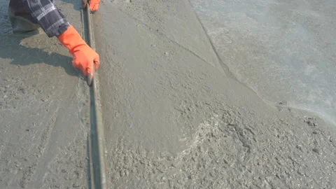 Construction workers are adjusting the surface of the cement floor by plastering Stock Footage 134745946