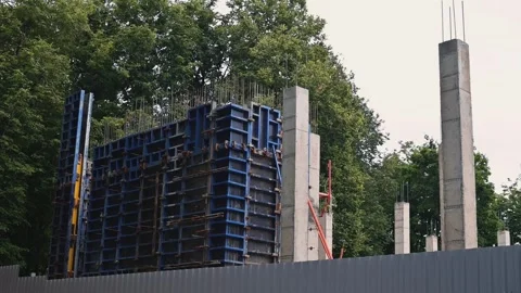 Construction workers are assembling concrete forms for a building structure in Stockbeeldmateriaal 344528080