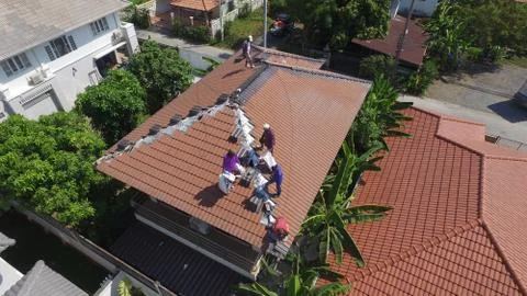Construction workers are fixing roofs in the morning. Stock Photos