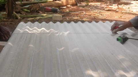 Construction workers are marking cutting lines on corrugated asbestos Stock Footage 333348492