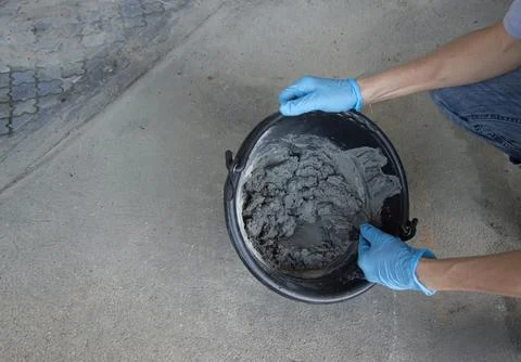 Construction workers are mixing cement in a bucket. Stock Photos