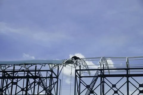 A construction workers are on the scaffolding against a bright blue sky Stock Photos