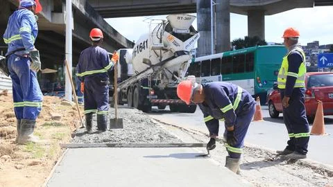 Construction workers are seen pouring concrete Stock Photos