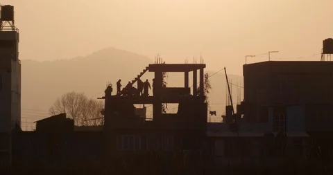 Construction workers are silhouetted by the evening sun Video stock 119401635
