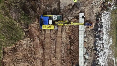 Construction workers are using heavy machinery to build a structure near the Video stock 336616068